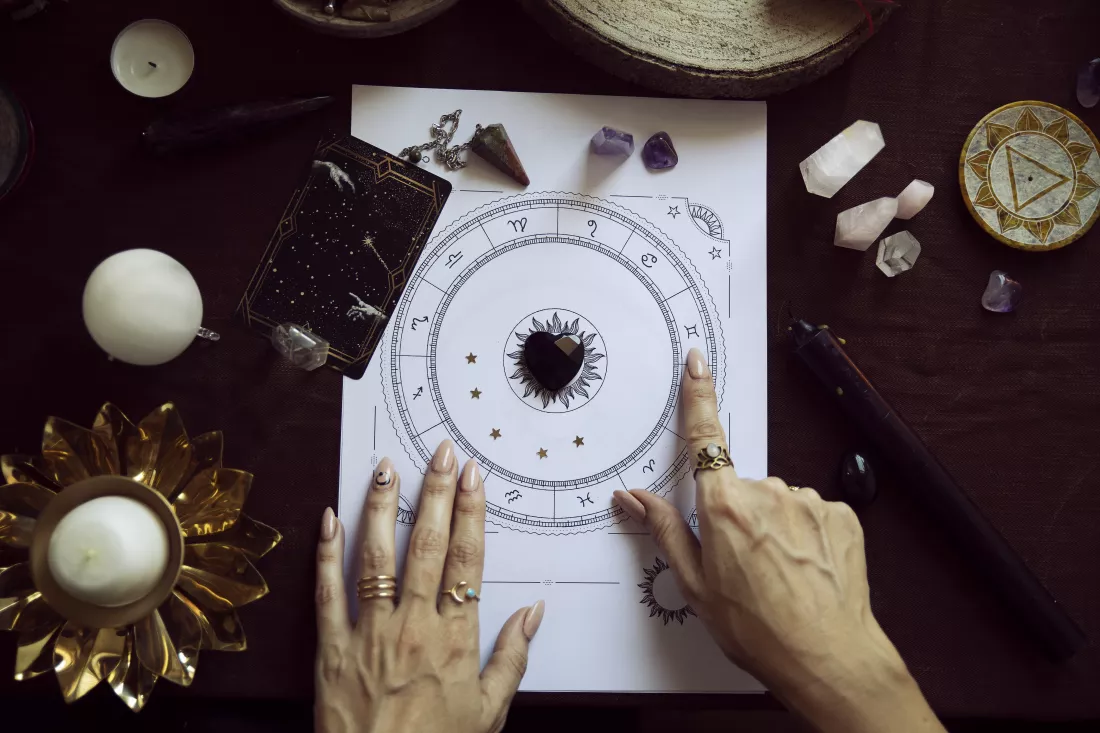 top-view-woman-pointing-zodiac-symbol-person-s-birth-chart-her-witch-altar-with-autumn-colors-some-candles-quartz-crystals